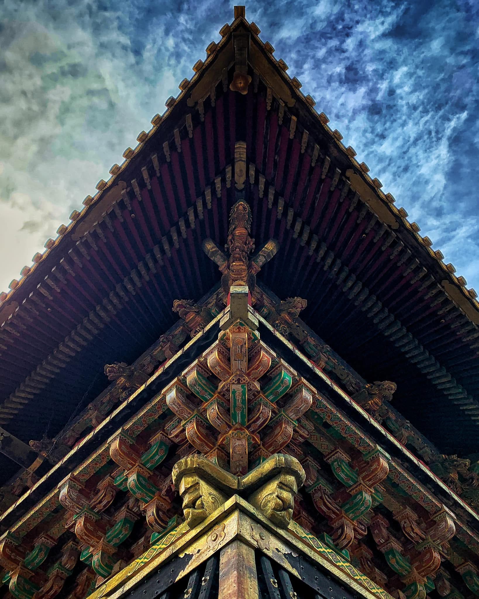 Ornate roofline of a Japanese temple against a blue sky